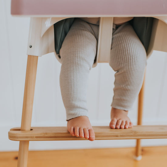 Child with feet on IKEA highchair footrest