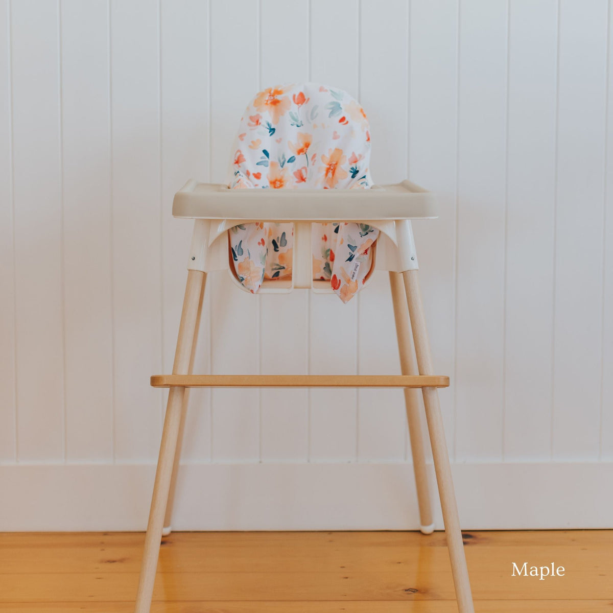 Posture & Comfort Kit on an IKEA Antilop highchair: maple footrest, floral cushion cover and support insert