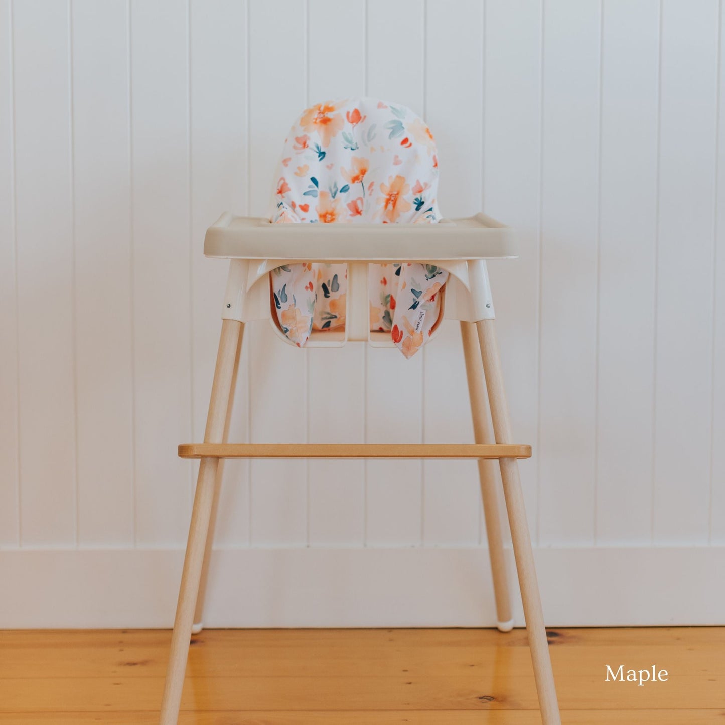 Posture & Comfort Kit on an IKEA Antilop highchair: maple footrest, floral cushion cover and support insert
